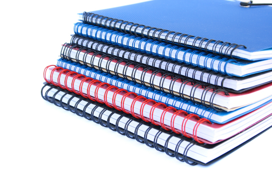 Stack of colorful copybooks isolated on white background.